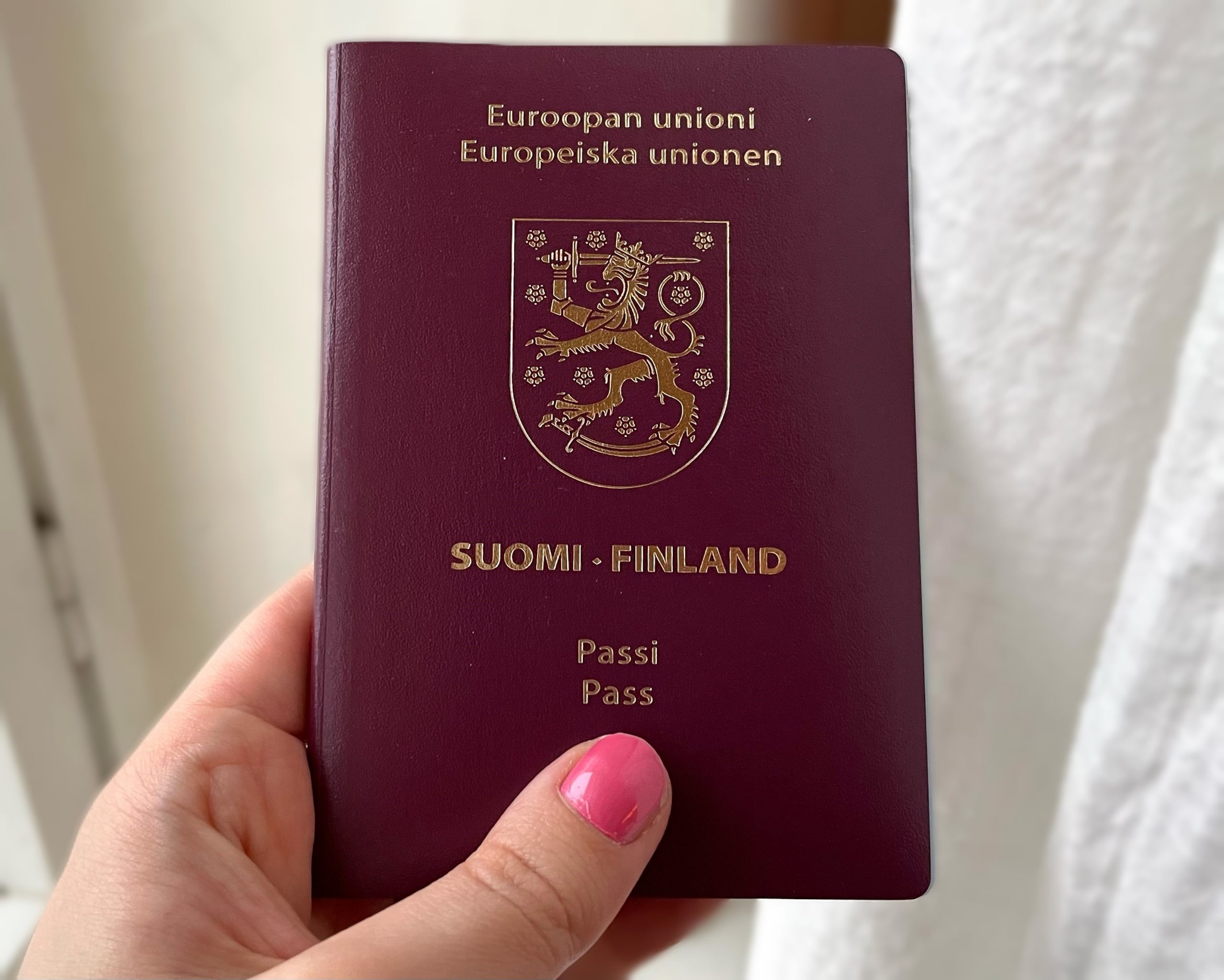 Kuva Suomen passista ihmisen kädessä.
